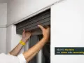 Hände montieren Dämmmaterial zum Rolladenkasten verkleiden. Ideal für Revision von unten oder raumseitig.