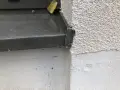 Detailaufnahme einer Fensterbank, die mit Klebeband provisorisch abgedichtet ist. Die raue Fassade und die graue Fensterbank sind gut erkennbar.