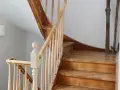 Eine alte Holztreppe wartet auf ihre Renovierung. Die Stufen und das Geländer aus hellem Holz zeigen Gebrauchsspuren, bereit für ein neues Leben.
