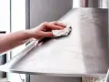 Hand poliert Edelstahl-Dunstabzugshaube mit einem Tuch für strahlenden Glanz.