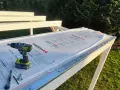 Werkzeug liegt bereit, um Hohlkammerplatten zu schneiden. Ein Akkuschrauber, Cutter und Schrauben auf der neuen Überdachung.