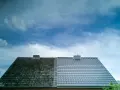 Vergleich: Eine Dachhälfte ist stark bemoost, die andere frisch beschichtet. Mögliche Nachteile der Dachbeschichtung sind hier nicht sichtbar.