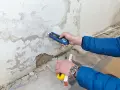 Feuchtemessung an einer Wand. Die isotec Kosten pro qm für eine Sanierung hängen vom Ausmaß des Schadens ab.