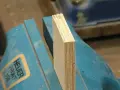 Holzplatte wird in Schraubstock eingespannt, um sie vorzubohren.