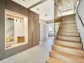 Moderne Diele mit Sitzbank und Garderobe, die Treppe aus verschiedenen **Hartholzarten** strahlt Wärme aus.