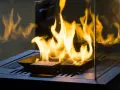 Flammen tanzen in einem modernen, gläsernen Kamin. Ein stilvoller holzofen ohne schornstein, der Wärme und Gemütlichkeit ausstrahlt.