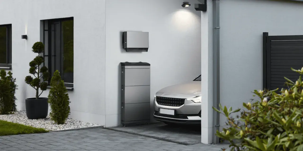 Moderner pv-speicher aufstellort garage, neben einem silbernen Elektroauto.