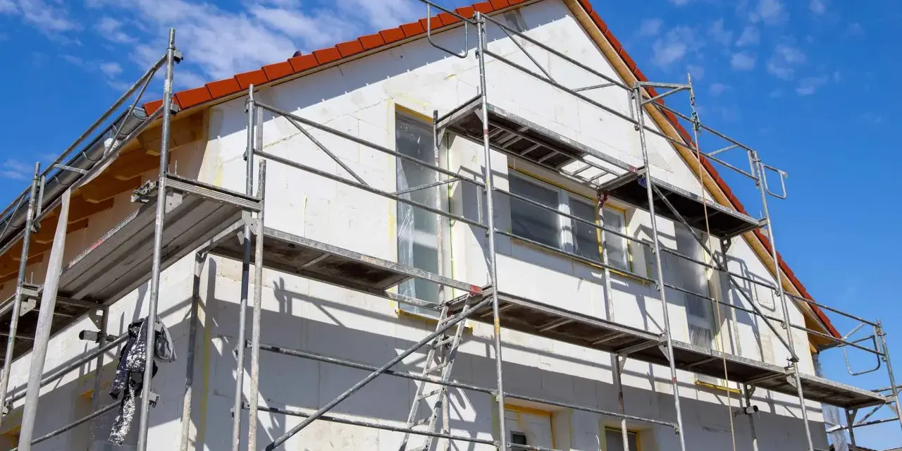 Haus mit Gerüst für Fassadensanierung. Die Kosten für eine Fassadensanierung können stark variieren.