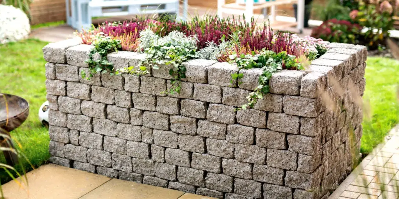 Ein Hochbeet aus Bruchsteinmauern bauen – mit dieser stabilen Steinmauer wird es zum Blickfang im Garten.