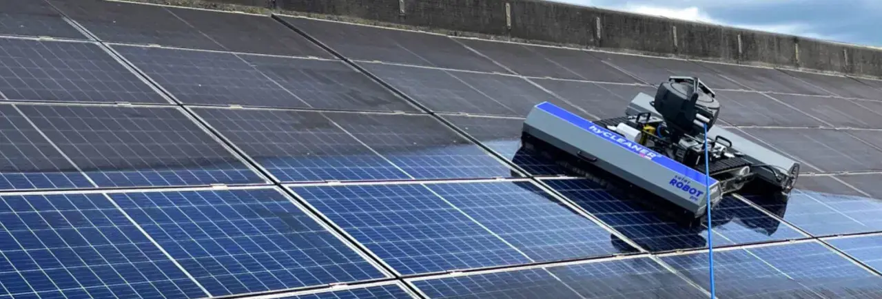 Ein Roboter reinigt eine Photovoltaikanlage. Die Reinigung der Solarmodule durch den Roboter sorgt für maximale Energieausbeute.