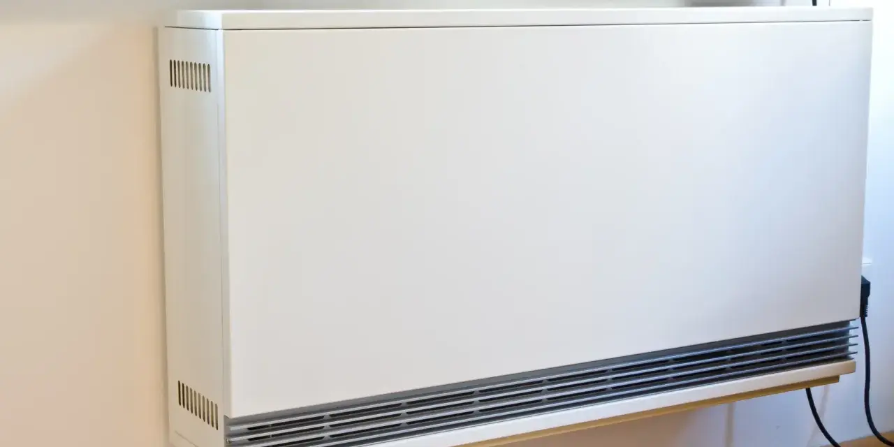 Ein weißes, modernes Heizgerät an der Wand, bereit, eine alte Nachtspeicherheizung zu ersetzen.