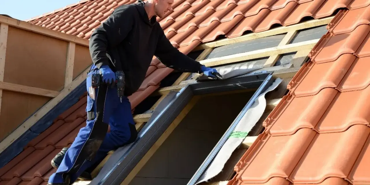 Handwerker installiert Dachfenster. Informieren Sie sich über den Dachfenster Zuschuss für Ihr Zuhause.