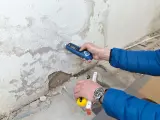 Feuchtemessung an einer Wand. Die isotec Kosten pro qm für eine Sanierung hängen vom Ausmaß des Schadens ab.