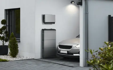 Moderner pv-speicher aufstellort garage, neben einem silbernen Elektroauto.