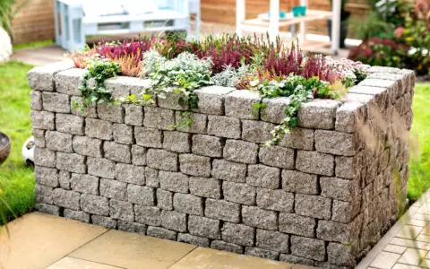 Ein Hochbeet aus Bruchsteinmauern bauen – mit dieser stabilen Steinmauer wird es zum Blickfang im Garten.