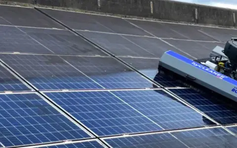 Ein Roboter reinigt eine Photovoltaikanlage. Die Reinigung der Solarmodule durch den Roboter sorgt für maximale Energieausbeute.