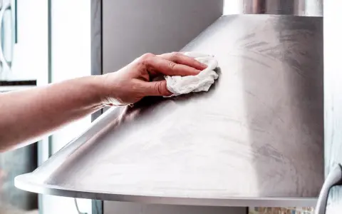 Hand poliert Edelstahl-Dunstabzugshaube mit einem Tuch für strahlenden Glanz.
