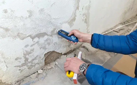 Feuchtemessung an einer Wand. Die isotec Kosten pro qm für eine Sanierung hängen vom Ausmaß des Schadens ab.