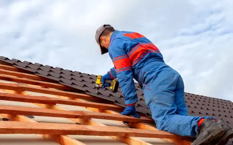 Handwerker montiert mit Akkuschrauber neue Dachziegel. Informieren Sie sich über die **Blechdach Kosten** für Ihr Projekt.