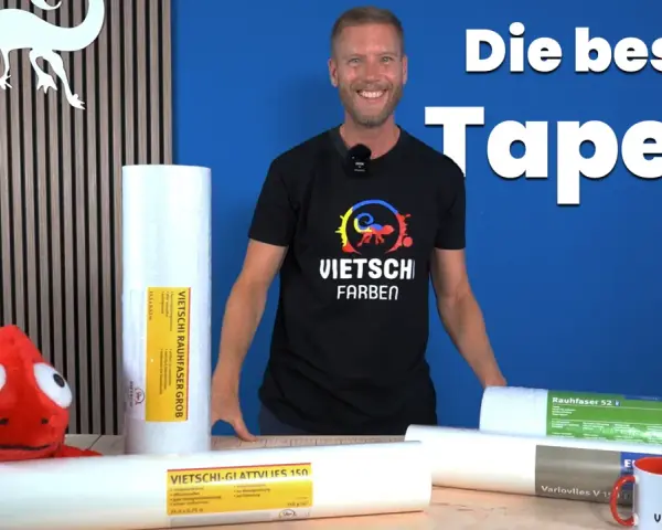 Mann präsentiert Rollen mit Vliestapete oder Raufaser. Die beste Tapete für dein Zuhause!