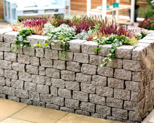 Ein Hochbeet aus Bruchsteinmauern bauen – mit dieser stabilen Steinmauer wird es zum Blickfang im Garten.