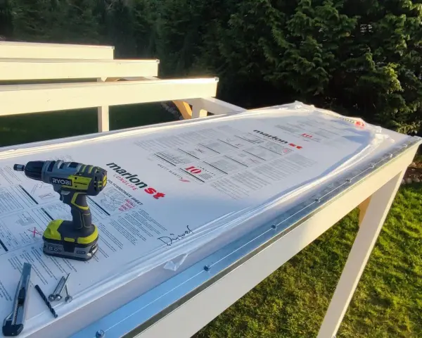 Werkzeug liegt bereit, um Hohlkammerplatten zu schneiden. Ein Akkuschrauber, Cutter und Schrauben auf der neuen Überdachung.