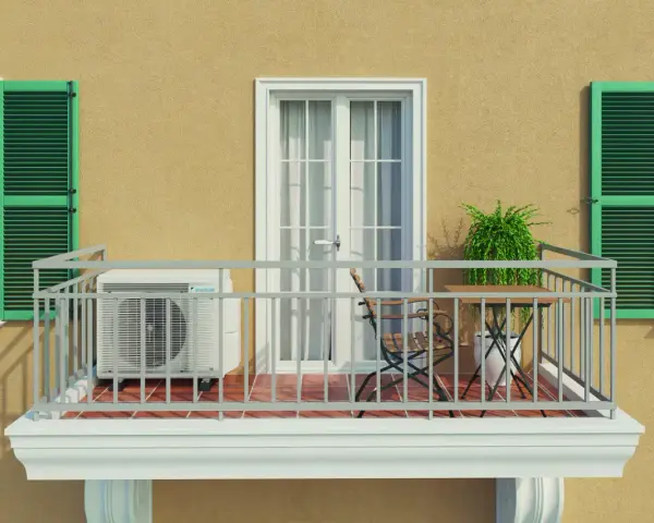 Balkon eines Mehrfamilienhauses mit Klimaanlage, Tisch und Stuhl. Grüne Fensterläden und eine Tür mit Vorhängen.