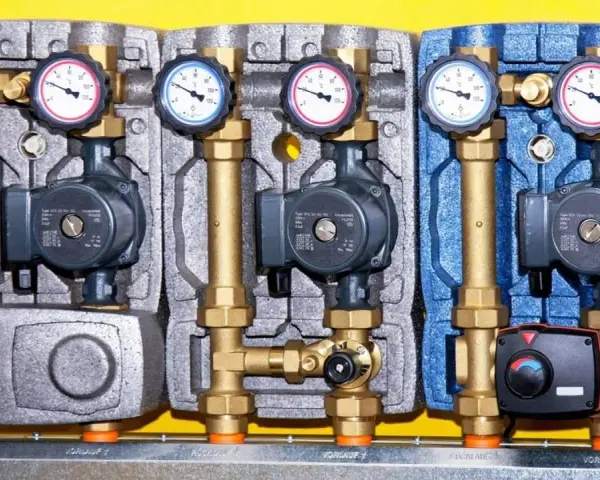 Drei Heizkreispumpen mit Manometern und Ventilen, die die hydraulische weiche Funktion für effiziente Wärmeübertragung demonstrieren.