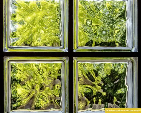 Fenster mit Glasbausteinen, die grünes Laub und Bäume durchscheinen lassen. Ideal, um alte Fenster durch moderne Glasbausteine zu ersetzen.