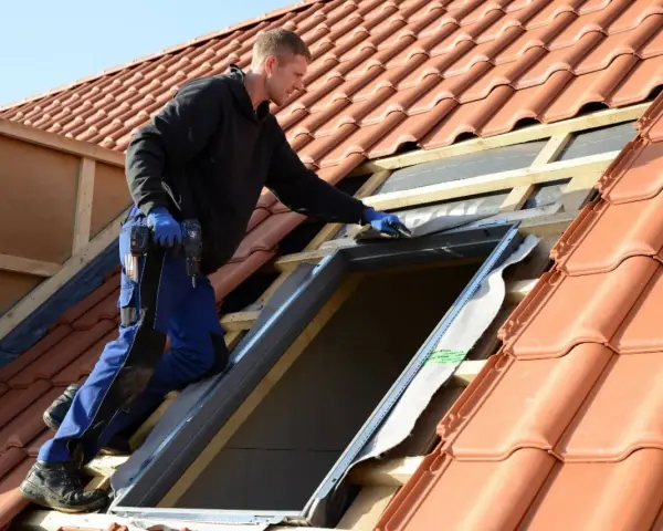 Handwerker installiert Dachfenster. Informieren Sie sich über den Dachfenster Zuschuss für Ihr Zuhause.