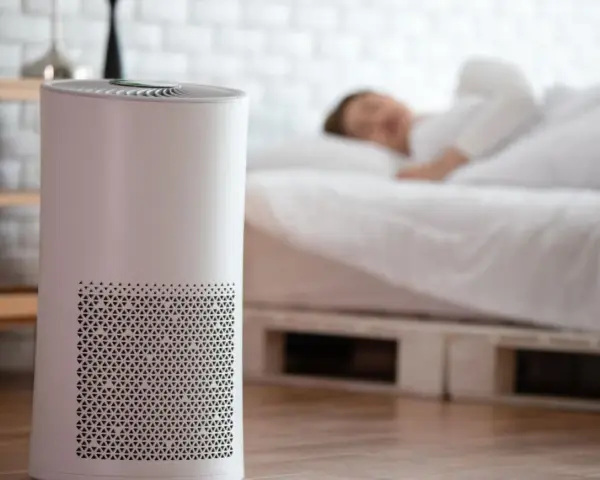 Luftreiniger bekämpft Feuchtigkeit im Schlafzimmer, während eine Person friedlich schläft.