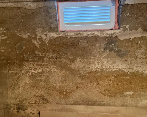 Feuchte Wände im Keller eines alten Hauses, deutet auf Grundwasser im Keller hin. Ein kleines Fenster ist sichtbar.