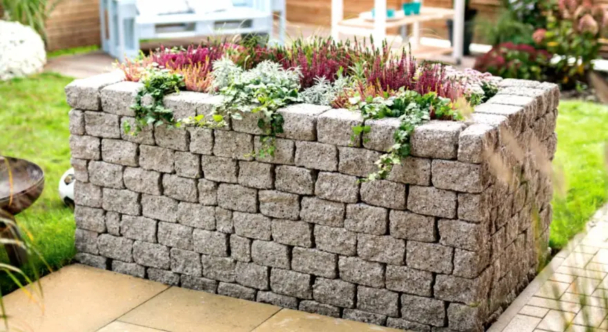 Ein Hochbeet aus Bruchsteinmauern bauen – mit dieser stabilen Steinmauer wird es zum Blickfang im Garten.