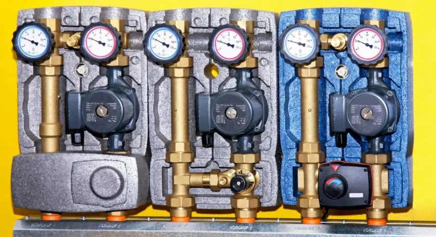 Drei Heizkreispumpen mit Manometern und Ventilen, die die hydraulische weiche Funktion für effiziente Wärmeübertragung demonstrieren.