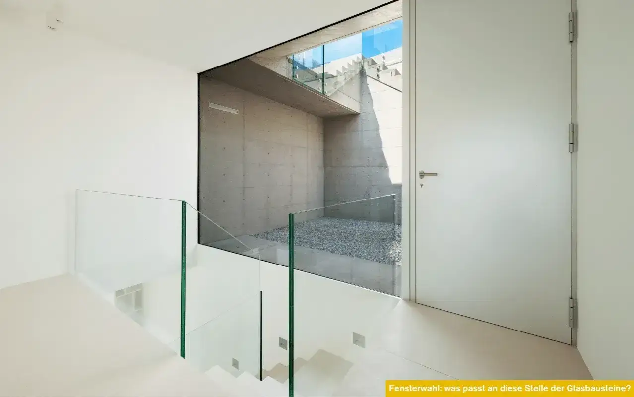 Moderne Treppe mit Glasgel&auml;nder, die eine Betonwand mit Kiesboden und Treppen im Freien freigibt. Eine gute Alternative, um Glasbausteine zu ersetzen.