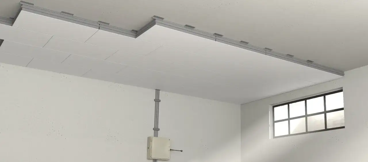 Isolierung der Kellerdecke mit Platten, die an einer Unterkonstruktion befestigt sind. Ein Fenster und Kabelkanäle sind sichtbar.