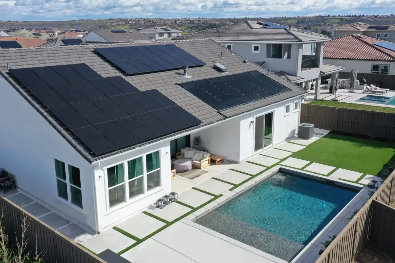 Modernes Haus mit Pool und Solaranlage auf dem Dach, das den KfW 70 Standard erfüllt.