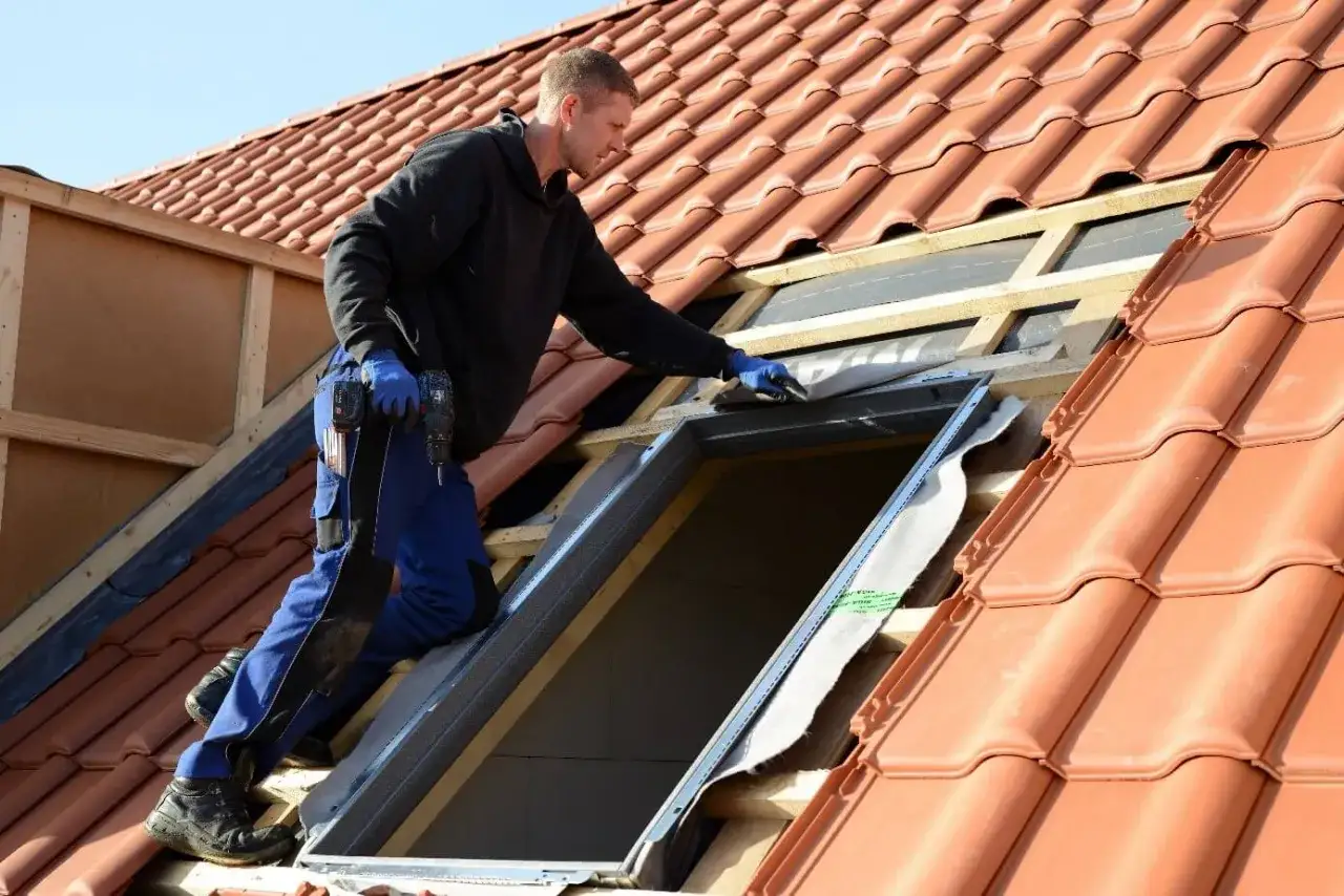 Handwerker installiert Dachfenster. Informieren Sie sich über den Dachfenster Zuschuss für Ihr Projekt.