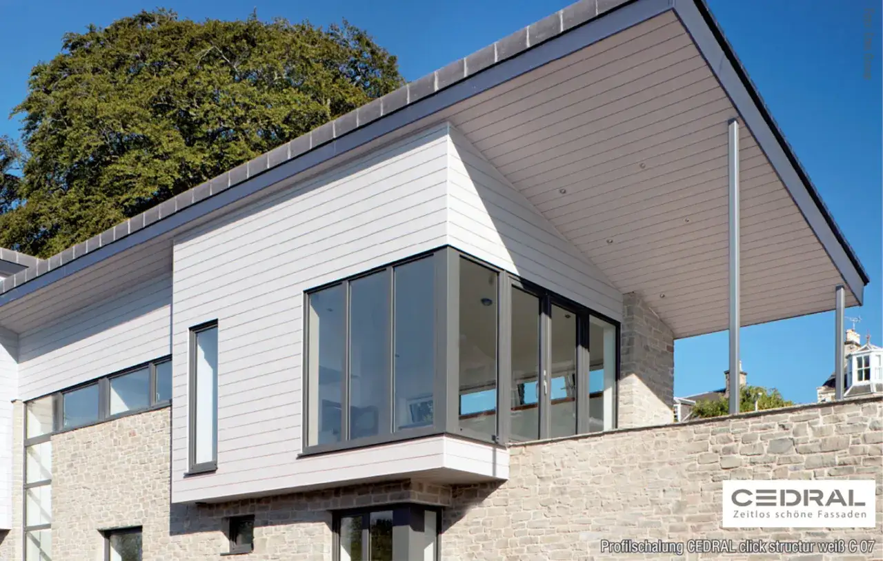Modernes Haus mit Steinfassade und weiß verkleideten Wänden. Die Fassade ist mit Cedral Click Struktur weiß C 07 verkleidet, eine tolle Alternative zum Eternitplatten streichen.