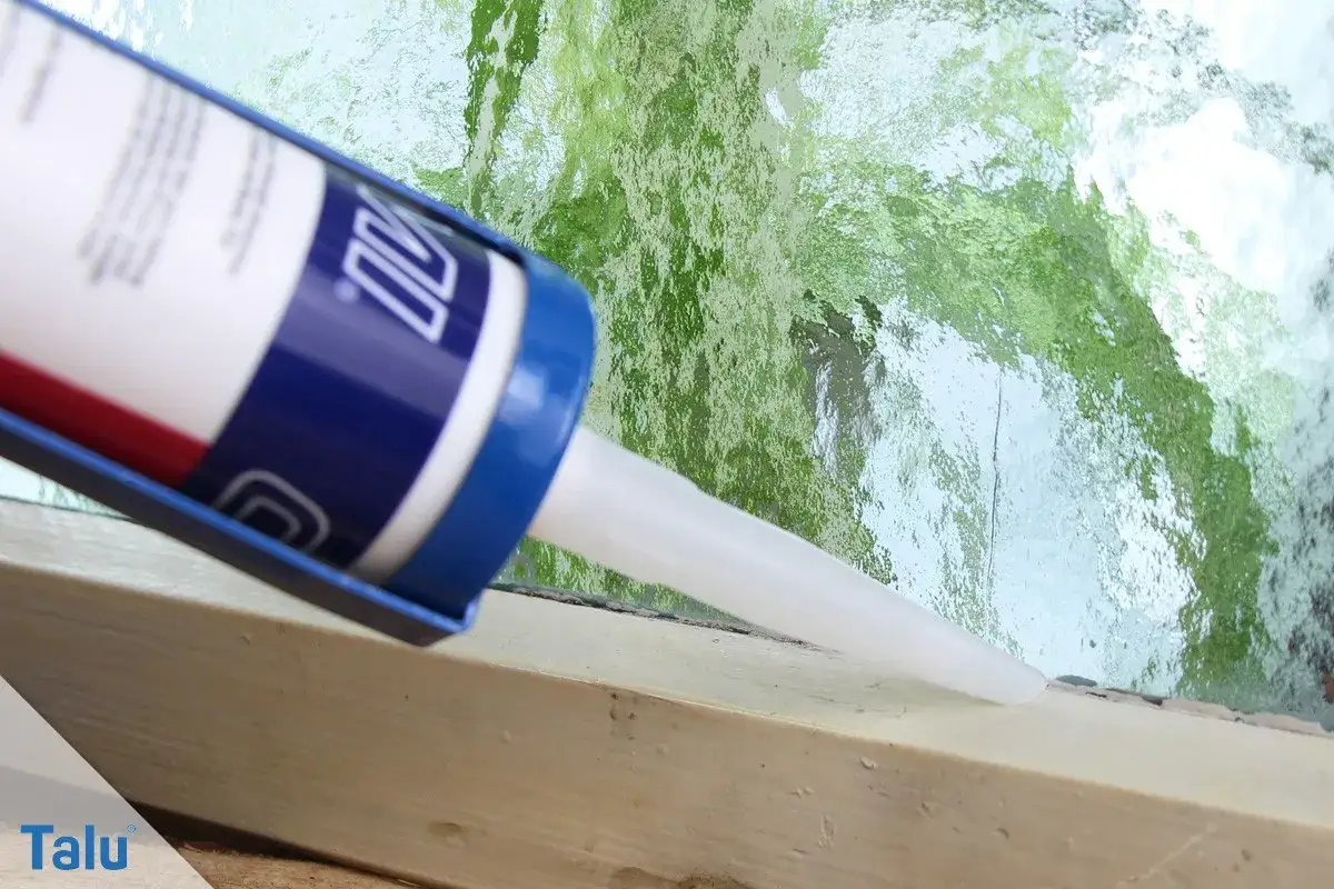 Mit einer Kartusche wird neues Fensterkitt aufgetragen, um alte Dichtungen zu erneuern und das Fenster abzudichten.