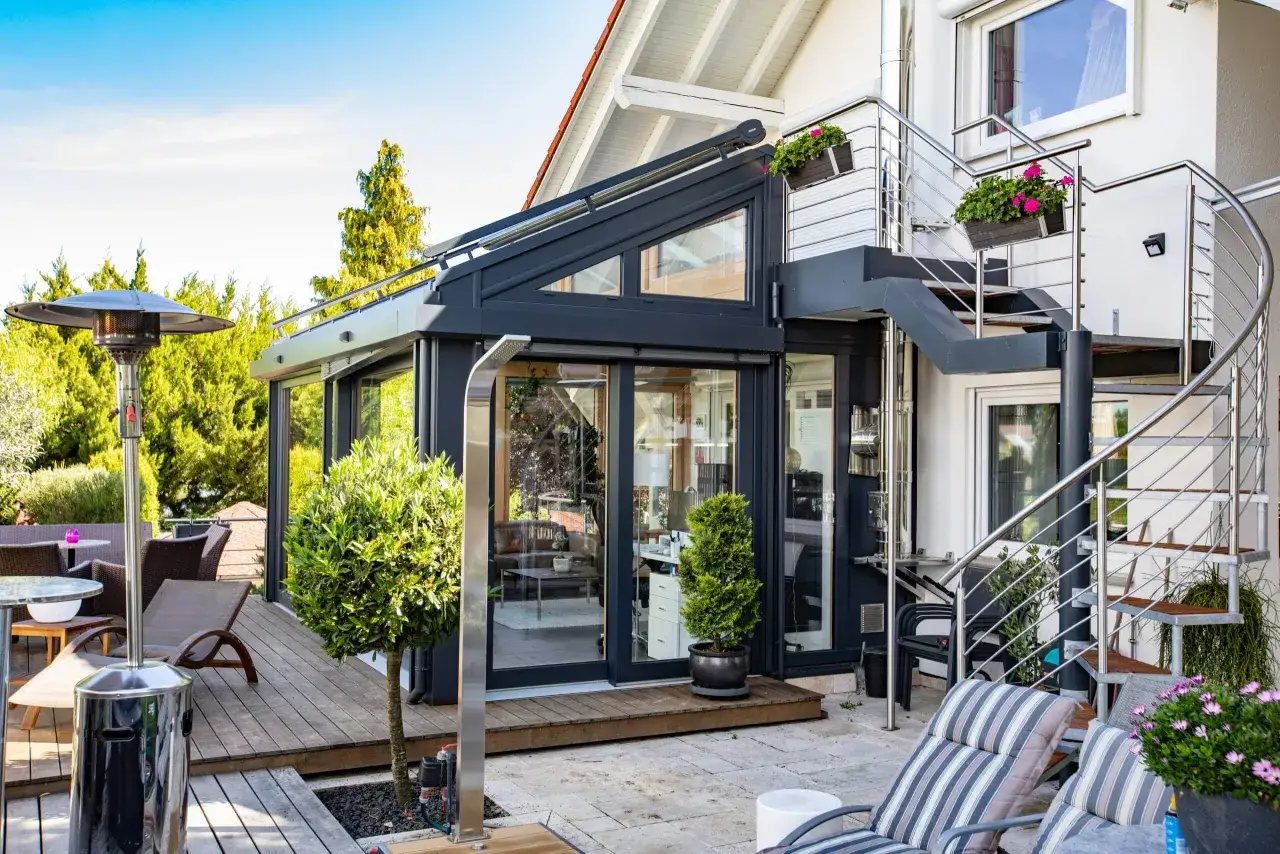 Moderner Wintergarten mit Au&szlig;entreppe und Heizstrahler. Perfekt f&uuml;r gem&uuml;tliche Abende im Freien, auch wenn es drau&szlig;en kalt ist.