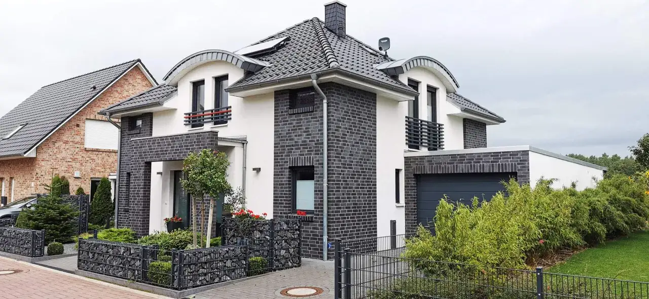 Modernhaus mit weißem Putz und dunklem Klinker. Die Fassade zeigt eine gelungene Kombination, die das Haus optisch aufwertet.