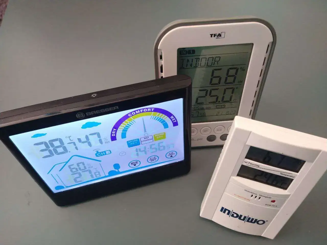 Drei digitale Wetterstationen zeigen Temperatur und Luftfeuchtigkeit an. Ein Ger&auml;t zeigt 68% Luftfeuchtigkeit und 25&deg;C an, ideal f&uuml;r ein gesundes Schlafzimmer.