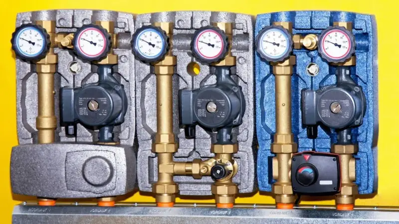 Drei Heizkreispumpen mit Manometern und Ventilen, die die hydraulische weiche Funktion für effiziente Wärmeübertragung demonstrieren.