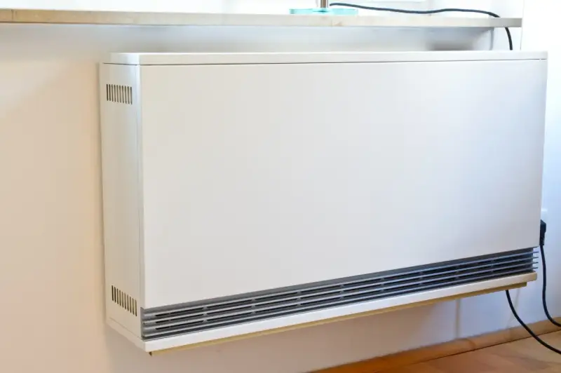 Ein weißes, modernes Heizgerät an der Wand, bereit, eine alte Nachtspeicherheizung zu ersetzen.